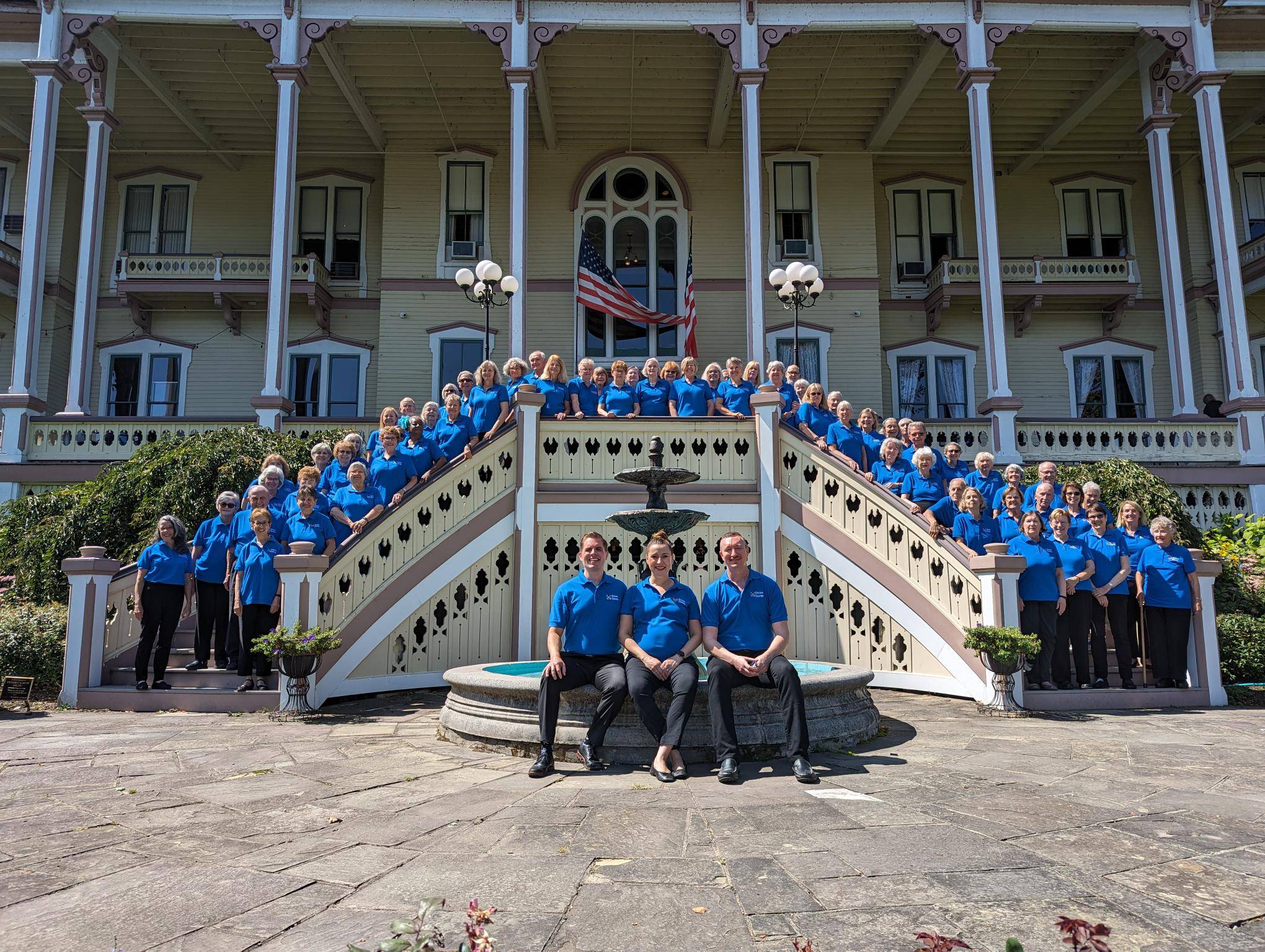 A photo of Encore singers and staff smiling outside the Aetheneum Hotel at Chautauqua Institution in 2024.